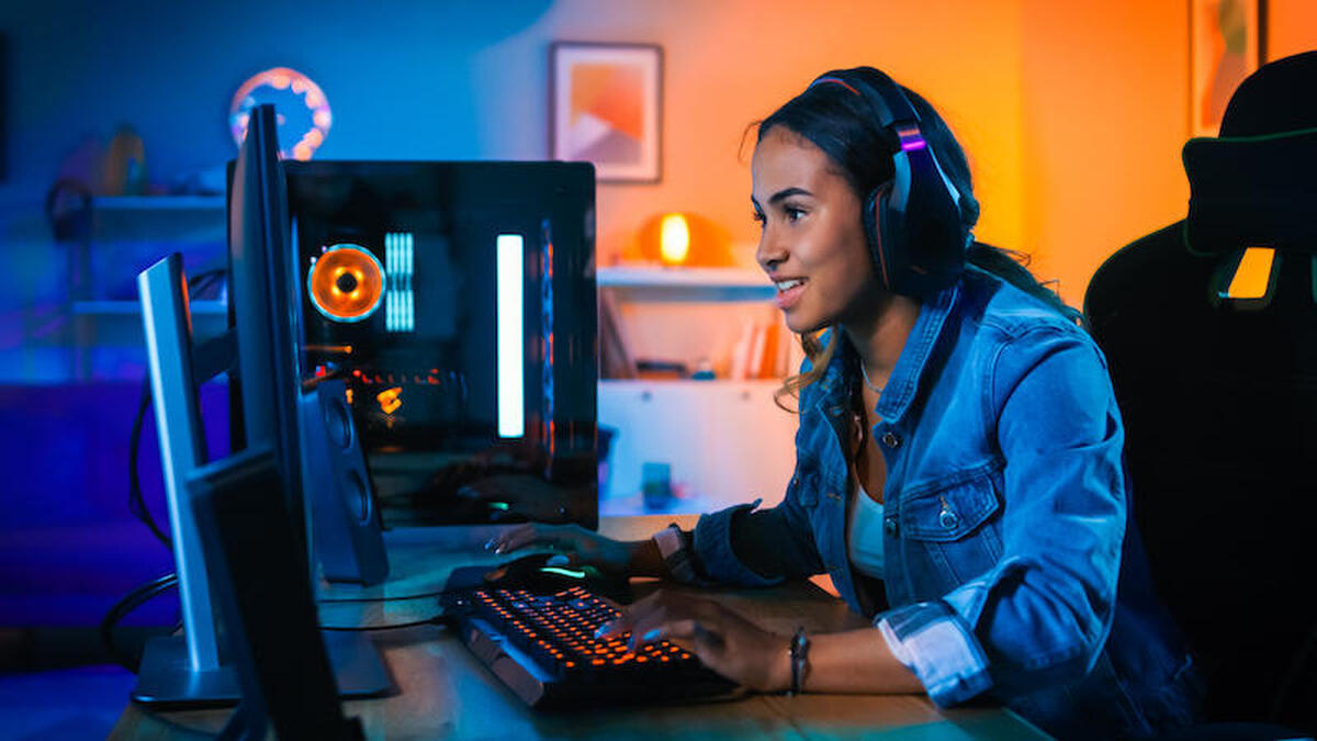 Gamer wearing headphones playing on a PC.